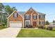 Charming two-story brick home featuring an attached garage, landscaped front yard, and a welcoming red front door at 3363 Linton Ln, Marietta, GA 30066