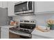 Close-up of a stainless steel range and microwave above a white countertop with subway tile backsplash at 340 Navigator Ln, Mcdonough, GA 30253