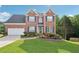 Charming brick two-story home with blue shutters, two-car garage, and lush, landscaped front yard at 3537 Castle View Ct, Suwanee, GA 30024