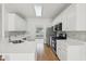 Modern kitchen with white cabinets, stainless steel appliances, quartz countertops, and hardwood floors at 3537 Castle View Ct, Suwanee, GA 30024