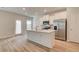 Bright kitchen features stainless appliances, white cabinets, and a center island with sink at 360 Navigator Ln, Mcdonough, GA 30253