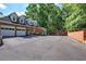 Home exterior with two-car garage, level driveway, and partial brick wall at 3695 Highway 140, Rydal, GA 30171