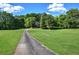 Picturesque home with a long driveway, green lawn, and surrounded by trees and lush landscape at 3695 Highway 140, Rydal, GA 30171