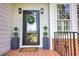 Inviting front entrance with a wreath-adorned door, decorative plants, and tiled porch at 3695 Highway 140, Rydal, GA 30171