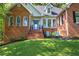 Charming brick home with manicured lawn and inviting front porch featuring two blue chairs at 3695 Highway 140, Rydal, GA 30171