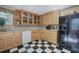 Kitchen with black and white checkerboard floors, wooden cabinets, and black refrigerator at 3695 Highway 140, Rydal, GA 30171