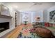 Open living room featuring a brick fireplace, hardwood floors, and colorful floral rug at 3695 Highway 140, Rydal, GA 30171