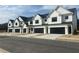 Modern townhome exteriors featuring white siding, black trim, and individual garages at 200 Starr Cir, Stockbridge, GA 30281
