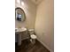 Elegant half bathroom featuring a pedestal sink, round mirror, and wood-look flooring at 2335 Hackamore Dr, Atlanta, GA 30349