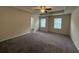 Large primary bedroom featuring neutral carpet, two windows, and ceiling fan at 2335 Hackamore Dr, Atlanta, GA 30349