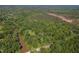 Aerial view featuring dense tree coverage with a body of water, road and cleared area near the tree line at 2520 Hollonville, Brooks, GA 30205