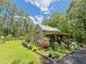 Landscaped yard with a charming home featuring a green metal roof and lush greenery at 2520 Hollonville, Brooks, GA 30205