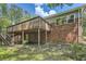 Two-story home featuring brick facade, complemented by a wooden deck and stairs leading to the verdant backyard at 2648 Woodacres Ne Rd, Atlanta, GA 30345