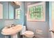Clean bathroom with pedestal sink, classic fixtures, and natural light from the window at 2648 Woodacres Ne Rd, Atlanta, GA 30345