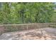 Large wooden deck with natural wood railing and bench seating surrounded by lush green trees and foliage at 2648 Woodacres Ne Rd, Atlanta, GA 30345