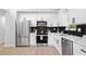 Contemporary kitchen with stainless steel appliances, white cabinets, and modern backsplash at 4058 Daron Ct, Ellenwood, GA 30294
