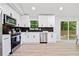 Updated kitchen featuring stainless steel appliances, white cabinets, and access to outdoor deck at 4058 Daron Ct, Ellenwood, GA 30294