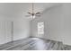 A bright bedroom featuring gray wood floors and a ceiling fan at 1043 Lexus Dr, Lawrenceville, GA 30045