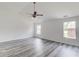 Spacious bedroom with light gray wood-look floors, white walls, a ceiling fan, and three windows at 1043 Lexus Dr, Lawrenceville, GA 30045
