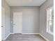 Bedroom with grey walls and wood-look flooring has doors on either side and a large window at 1043 Lexus Dr, Lawrenceville, GA 30045
