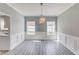Bright dining room featuring wainscoting, modern lighting, and plank flooring at 1043 Lexus Dr, Lawrenceville, GA 30045