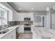 This kitchen boasts stainless steel appliances, a mosaic tile backsplash, and a marble countertop island at 1043 Lexus Dr, Lawrenceville, GA 30045