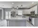 Well-lit kitchen features stainless steel appliances, white cabinets, and a center island with a marble countertop at 1043 Lexus Dr, Lawrenceville, GA 30045