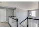 Second-floor landing with a staircase, window, light fixture, gray walls, and wood-look flooring at 1043 Lexus Dr, Lawrenceville, GA 30045