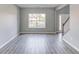 Spacious living room with plank flooring, staircase, and large window at 1043 Lexus Dr, Lawrenceville, GA 30045