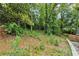 View of a backyard featuring lush greenery, mature trees, and a retaining wall at 2084 Bethel Nw Dr, Atlanta, GA 30314