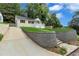 Well-manicured front yard features a retaining wall and driveway access to the street at 2084 Bethel Nw Dr, Atlanta, GA 30314
