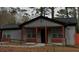 A well-maintained gray house with orange pillars and accent, enclosed by a black chain-link fence at 3479 Thompson Nw Dr, Atlanta, GA 30331