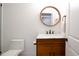 Bright half bathroom with wood vanity, marble counter, brushed-nickel faucet, and round mirror at 533 Beecham Dr, Smyrna, GA 30082