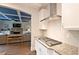 Modern kitchen showcasing a gas cooktop, stainless steel hood, granite countertops, and an open layout into the living space at 533 Beecham Dr, Smyrna, GA 30082