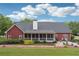Wide shot of the home's brick exterior with a large yard, a screened porch, and a patio area at 825 Kennedy Ct, Loganville, GA 30052