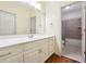 Well-lit bathroom features tile flooring, vanity with ample counter space, and tiled shower in the background at 825 Kennedy Ct, Loganville, GA 30052