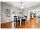 Bright breakfast nook featuring wood floors, modern lighting fixture, a ceiling fan, and backyard access at 825 Kennedy Ct, Loganville, GA 30052