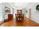 Formal dining room featuring hardwood floors, wainscoting, and elegant chandelier lighting at 825 Kennedy Ct, Loganville, GA 30052