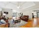 Elegant living room with hardwood floors, coffered ceilings, area rug, and comfortable leather seating at 825 Kennedy Ct, Loganville, GA 30052