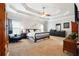 Spacious bedroom featuring a tray ceiling, ceiling fan and large windows allowing natural light to enter at 825 Kennedy Ct, Loganville, GA 30052
