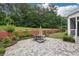 Paver patio and a seating area with an umbrella table in a landscaped backyard at 825 Kennedy Ct, Loganville, GA 30052