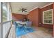 Comfortable covered porch with brick and wood accents and furniture for outdoor dining at 825 Kennedy Ct, Loganville, GA 30052