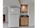 Basement kitchenette with wooden cabinets, stainless steel sink, and a refrigerator at 1450 Holly Bank Cir, Atlanta, GA 30338