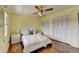 Bright bedroom with hardwood floors, yellow walls, ceiling fan, and closet with bi-fold doors at 1450 Holly Bank Cir, Atlanta, GA 30338