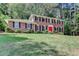 Traditional brick home with black shutters, a bright red door, and a well-manicured lawn at 1450 Holly Bank Cir, Atlanta, GA 30338
