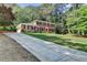 Charming brick home with a long driveway surrounded by lush greenery and mature trees at 1450 Holly Bank Cir, Atlanta, GA 30338