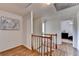 Hallway with hardwood floors, a wooden staircase, and a view of a bedroom with black furniture at 1450 Holly Bank Cir, Atlanta, GA 30338