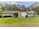 White exterior house with a large, green backyard and a patio seating area at 1981 Luke Edwards Rd, Dacula, GA 30019