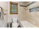 Bright bathroom features updated tiling, a window, and a shower and tub combo at 1981 Luke Edwards Rd, Dacula, GA 30019