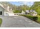 Inviting white home featuring an expansive driveway and a charming front porch surrounded by lush greenery at 1981 Luke Edwards Rd, Dacula, GA 30019